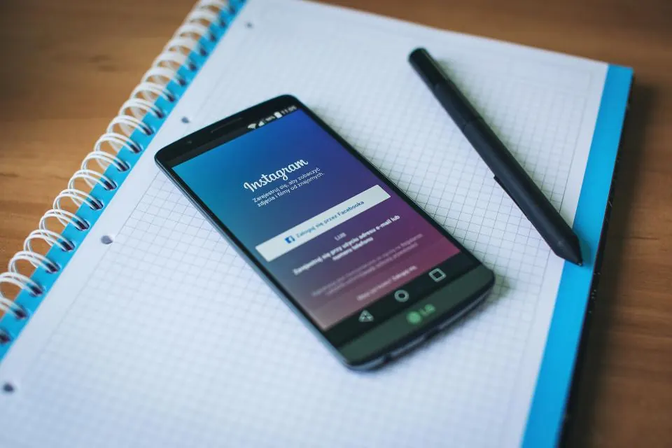 Sisältökalenterivihko ja puhelin, jossa Instagram auki